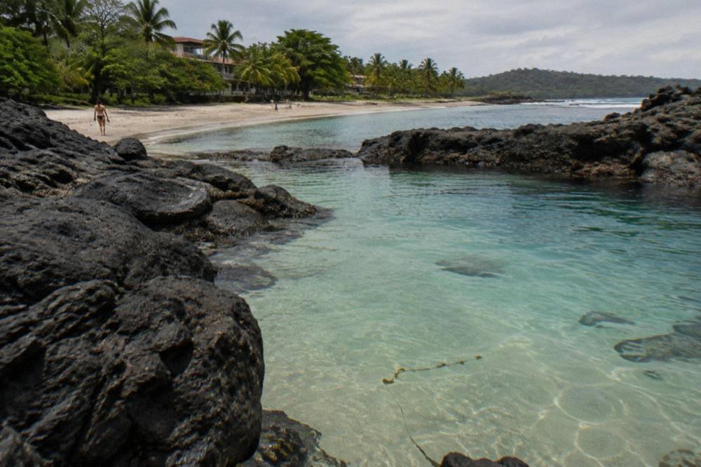 Calm turquoise water over a small rocky cove with visible sandy bottom